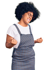 Sticker - Young african american girl wearing casual clothes very happy and excited doing winner gesture with arms raised, smiling and screaming for success. celebration concept.