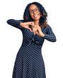 Young african american woman wearing casual clothes and glasses smiling in love doing heart symbol shape with hands. romantic concept.