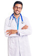 © Krakenimages.com - Young hispanic man wearing doctor uniform and stethoscope happy face smiling with crossed arms looking at the camera. positive person.