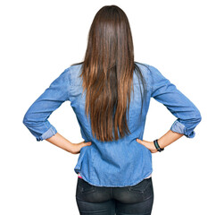 Young brunette woman wearing casual clothes standing backwards looking away with arms on body