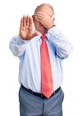 Canvas Print - Senior handsome grey-haired man wearing elegant tie and shirt covering eyes with hands and doing stop gesture with sad and fear expression. embarrassed and negative concept.