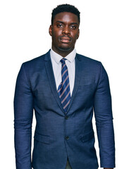 Handsome business black man wearing business suit and tie relaxed with serious expression on face. simple and natural looking at the camera.