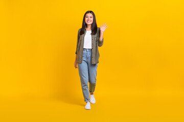 Wall Mural - Full body size photo of young cute smiling model japanese girl wear casual outfit palm shaking hello isolated on bright yellow color background