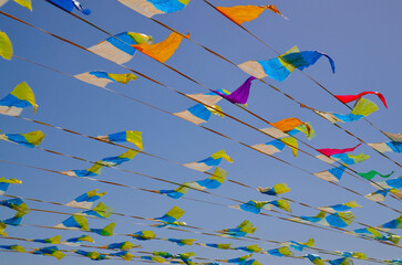 Multicolored triangular small flags to celebration party against blue sky.Street holiday concept for design.Selective focus.