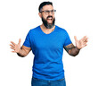 © Krakenimages.com - Hispanic man with beard wearing casual t shirt and glasses crazy and mad shouting and yelling with aggressive expression and arms raised. frustration concept.