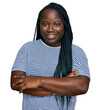 © Krakenimages.com - Young black woman with braids wearing casual clothes happy face smiling with crossed arms looking at the camera. positive person.