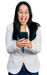 Wall Mural - Beautiful hispanic woman with nose piercing using smartphone typing message celebrating crazy and amazed for success with open eyes screaming excited.