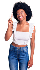 Canvas Print - Young african american woman wearing casual clothes showing and pointing up with finger number one while smiling confident and happy.