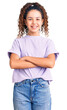 © Krakenimages.com - Beautiful kid girl with curly hair wearing casual clothes happy face smiling with crossed arms looking at the camera. positive person.