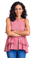 Wall Mural - Middle age beautiful woman wearing casual sleeveless t shirt skeptic and nervous, disapproving expression on face with crossed arms. negative person.