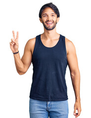 Poster - Handsome hispanic man wearing casual clothes smiling with happy face winking at the camera doing victory sign. number two.