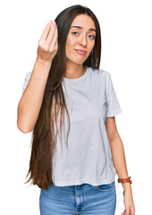 Poster - Young hispanic girl wearing casual white t shirt doing italian gesture with hand and fingers confident expression