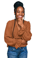 Poster - Young african american woman wearing casual clothes looking confident at the camera smiling with crossed arms and hand raised on chin. thinking positive.