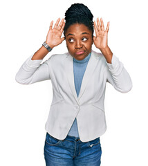 Wall Mural - Young african american woman wearing business clothes doing bunny ears gesture with hands palms looking cynical and skeptical. easter rabbit concept.