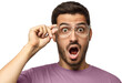 © Damir Khabirov - Young man shouting wow with open mouth, surprised by low price and sale, holding glasses