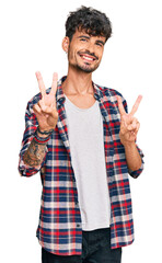 Poster - Young hispanic man wearing casual clothes smiling looking to the camera showing fingers doing victory sign. number two.