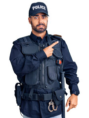 Sticker - Young hispanic man wearing police uniform pointing aside worried and nervous with forefinger, concerned and surprised expression