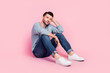 © deagreez - Full body photo of nice young guy sitting depressed dreaming bored thoughtful dressed trendy blue clothes isolated on pink color background