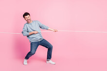 Full Length Photo Of Excited Guy Playing Tug War Game Pull String Isolated On Pastel Color Background