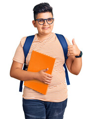 Little boy kid wearing student backpack holding books smiling happy and positive, thumb up doing excellent and approval sign