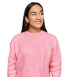 © Krakenimages.com - Young asian woman wearing casual winter sweater looking away to side with smile on face, natural expression. laughing confident.