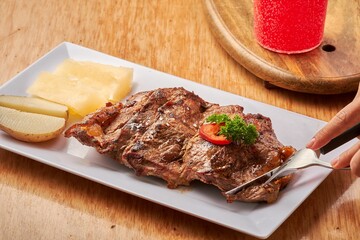 Sticker - Closeup of high heat charcoal grilled steak served with cheese and pear on a white rectangular plate