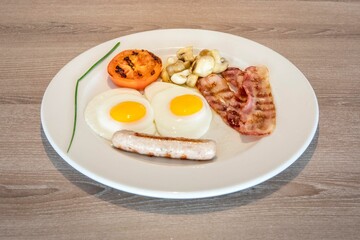 Sticker - Closeup of a delicious breakfast meal with two eggs, mushrooms, bacon and sausage