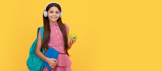 Sticker - happy school teen girl in headphones carry backpack and workbook with apple for lunch. Banner of schoolgirl student. School child pupil portrait with copy space.