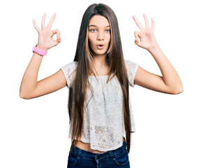 Poster - Young brunette girl with long hair wearing white shirt looking surprised and shocked doing ok approval symbol with fingers. crazy expression