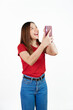 © Phushutter - Holding mobile, Pretty asian women England soccer fans celebrating over white background isolated. Sports fan isolated young woman.