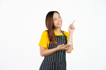 Received customer online order on mobile app, Portrait of confident asian woman barista and food owner shop with yellow t-shirt and black apron standing on white background.