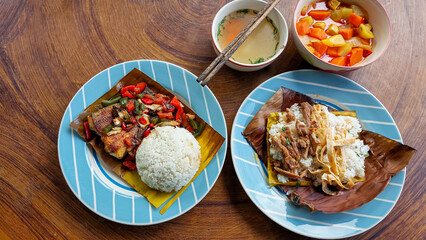 Top view of a table full of authentic traditional khmer food for breakfast of Trei boeng kanh chhet or spicy fried fish and Bai sach chrouk or pork with steamed rice