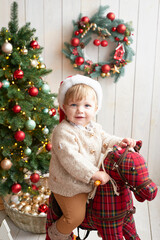 Santa baby. Beautiful child. Merry christmas and happy new year. Christmas tree background.