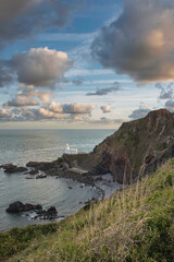 Wall Mural - Lovely sunrise landscape image of Devon coastline in England with stunning golden hour light on the land and sky