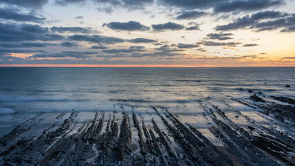 Wall Mural - Beautiful sunset landscape image of Welcome Mouth Beach in Devon England with beautiful rock formations