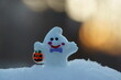 A toy ghost with a pumpkin on a sunset background. A fairy-tale character. Ideas for Halloween.