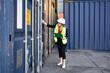 © Nassorn - Female foreman supervisor wears safety hardhat inspecting container cargo at warehouse storage terminal. Industrial engineer woman works outdoors at international import export distribution facility.