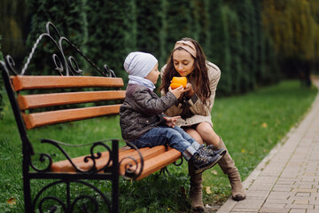 Mom and son walking and having fun together in the autumn park.