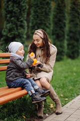 Mom and son walking and having fun together in the autumn park.