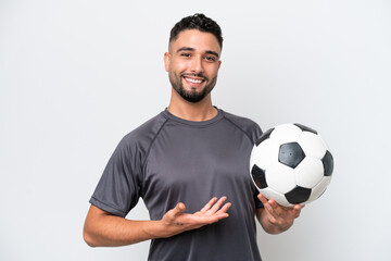 Wall Mural - Arab young football player man isolated on white background extending hands to the side for inviting to come