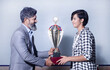 Indian man school teacher give victory trophy cup to girl student, Female receive winning prize.