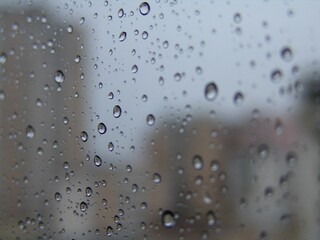 Sticker - Closeup shot of raindrops on glass with out of focus background