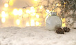 Weihnachtliches Bild mit Schnee und Tannenbaumkugel sowie funkelnde Lichter im Hintergrund