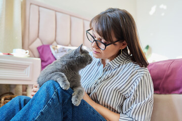 Wall Mural - Gray pet cat in the hands of woman owner