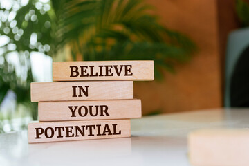 Wall Mural - Wooden blocks with words 'Believe in your potential'.