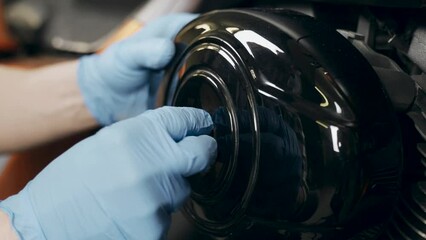 Poster - A mechanic screwing on a cap after replacing the air filter in a motorcycle. Close-up. Transport concept