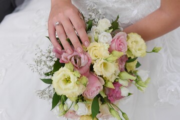 Wall Mural - Closeup of a bouquet of white and pink roses in bride's hand