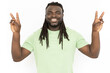 Happy man showing peace gestures at camera. Front view of smiling African American man looking and posing for camera, having fun while standing against white background. Happiness concept