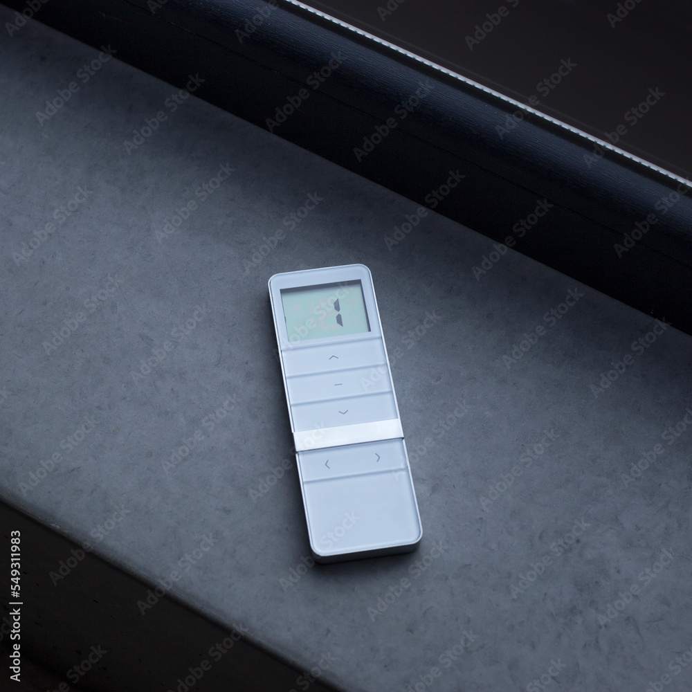 Windows Blind Remote Remote control for window blinds. White remote control lying on a ...