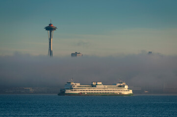 Wall Mural - Ferry Boat From Bainbridge Island On the Morning Commute To Seattle, Washington. Early morning sunrise commute and a ground fog layer make for a mystical transport to the Emerald City. 